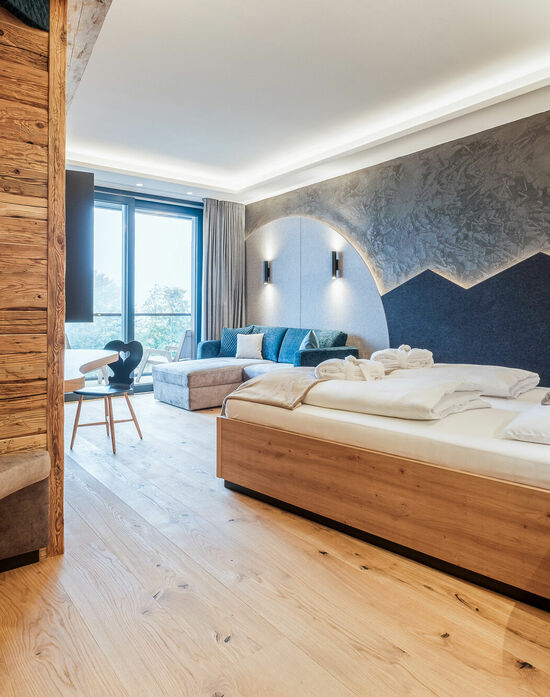 Kinderhotel Allgäuer Berghof – Wohnzimmer der Familien-Suite Spass-Suite mit Blick auf die Allgäuer Alpen