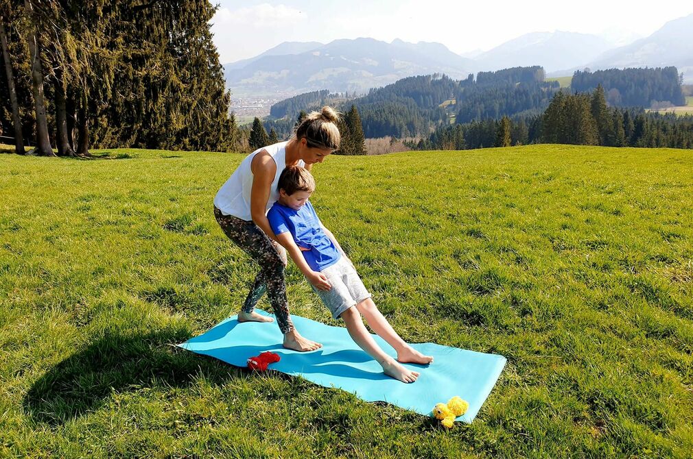 Aktiv sein mit der Yogaübung Vertrauen und Loslassen im Kinderhotel Allgäuer Berghof