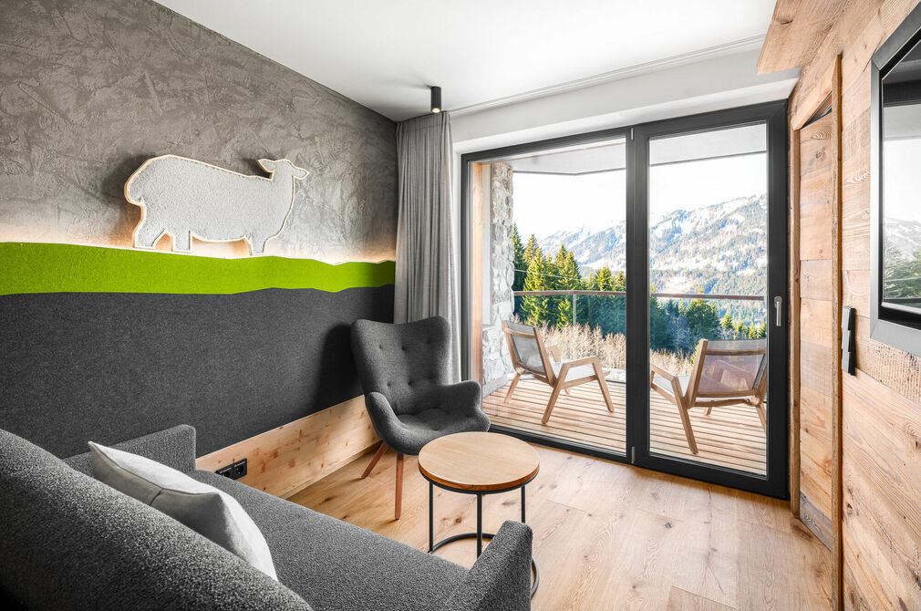 Kinderhotel Allgäuer Berghof – Wohnzimmer Familien-Suite Schafgemach mit Blick auf die Allgäuer Alpen